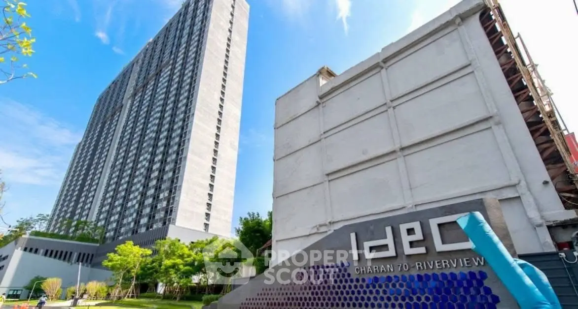 Modern high-rise building with lush greenery and clear blue sky