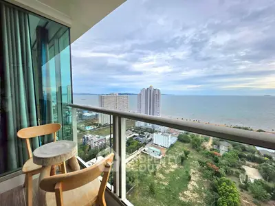 Stunning ocean view from a high-rise balcony with modern seating, perfect for relaxation and enjoying the scenery.