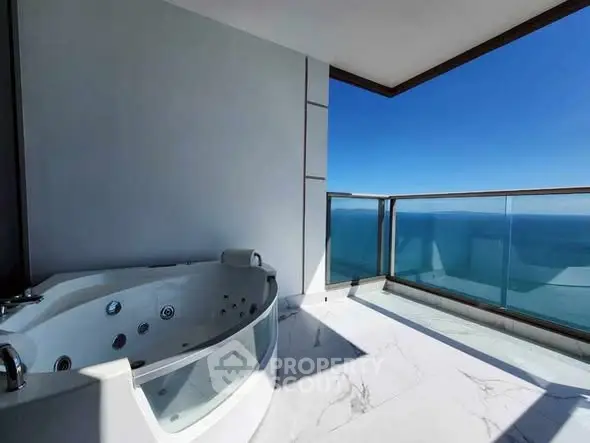 Luxurious balcony with ocean view and private jacuzzi, perfect for relaxation.