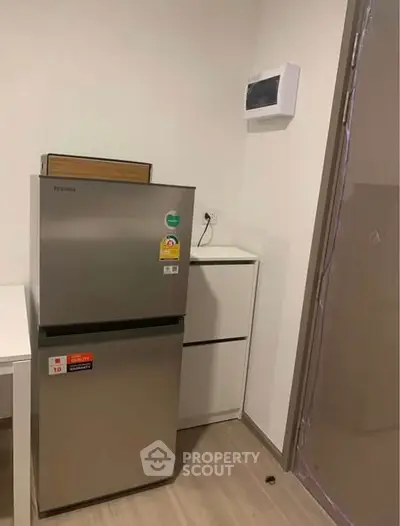 Modern kitchen corner with sleek fridge and minimalist design.