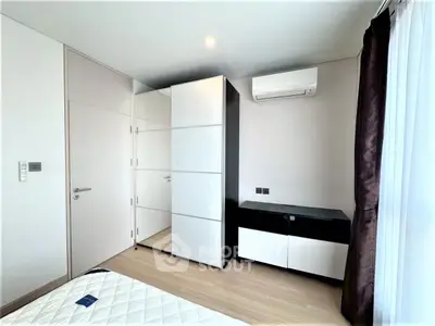 Modern bedroom with sleek furniture and air conditioning in a bright apartment.