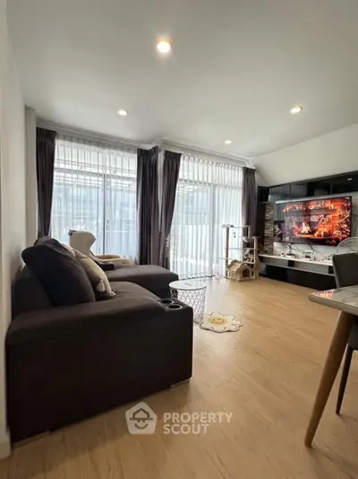 Modern living room with large windows and cozy seating area