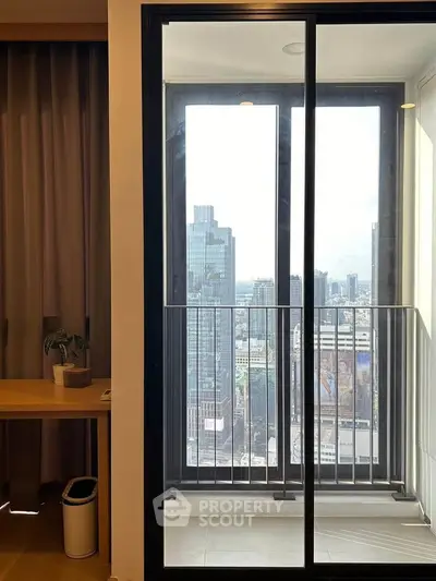 Modern apartment balcony with stunning city view through glass doors.