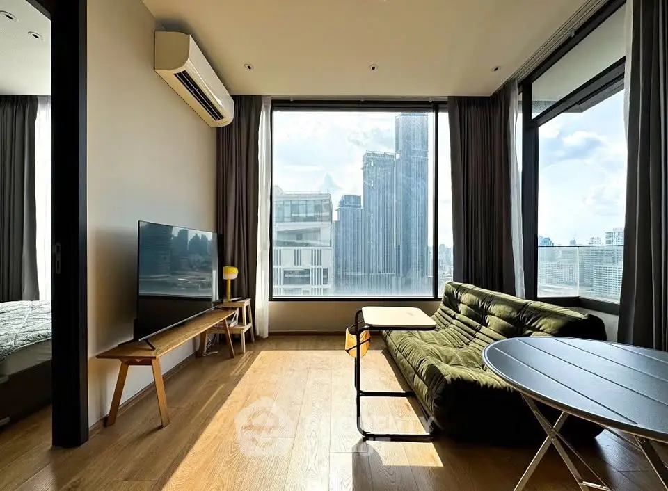 Modern living room with stunning city view, featuring sleek furniture and large windows for natural light.