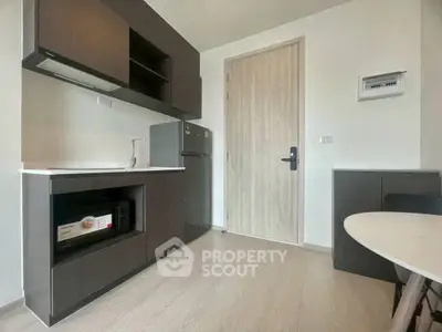 Modern kitchen with sleek cabinetry and compact fridge in a stylish apartment.