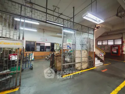 Industrial-style building interior with metal gates and concrete flooring, ideal for warehouse or storage use.