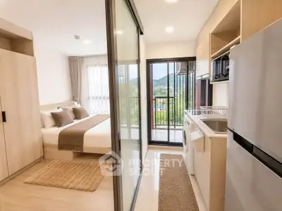 Modern studio apartment with bedroom and kitchen, featuring mountain view and sleek design.