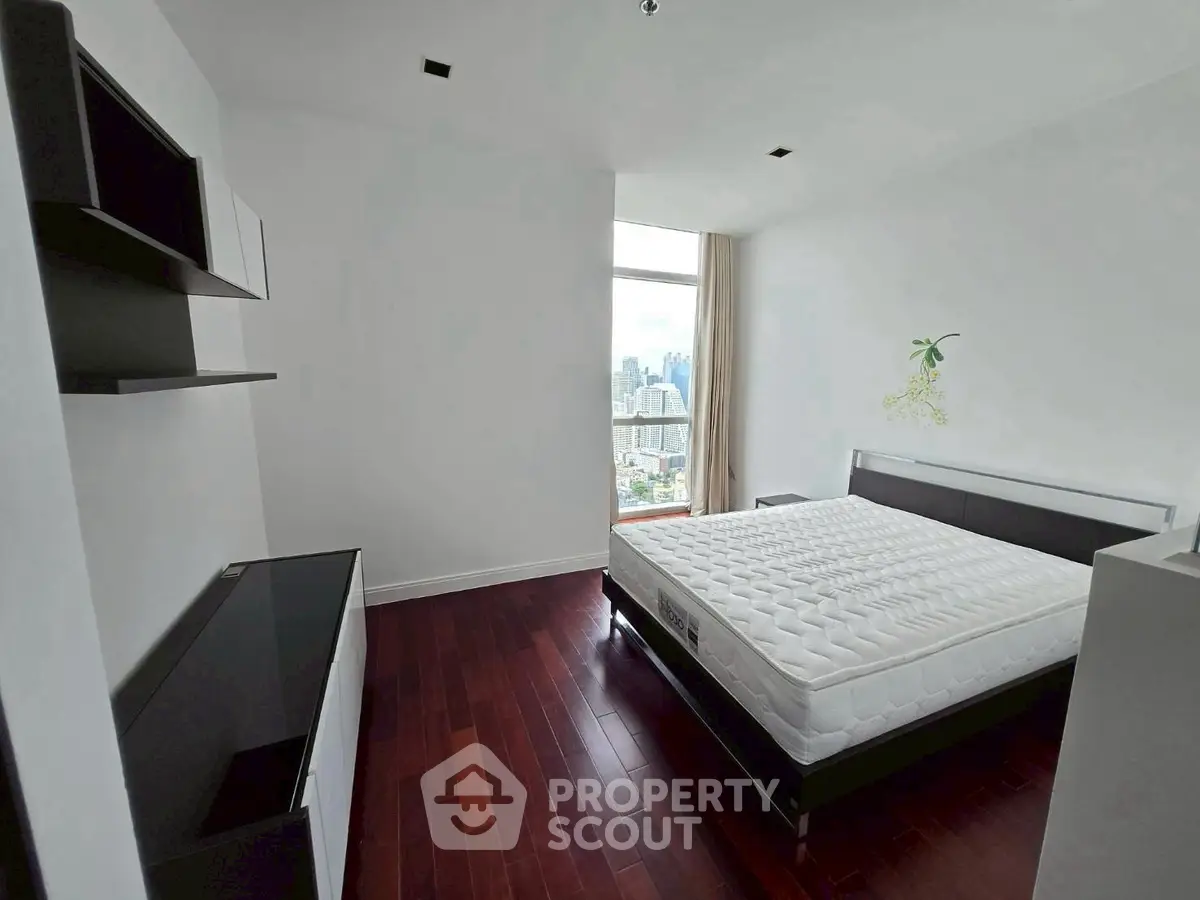 Spacious modern bedroom with city view and sleek furniture