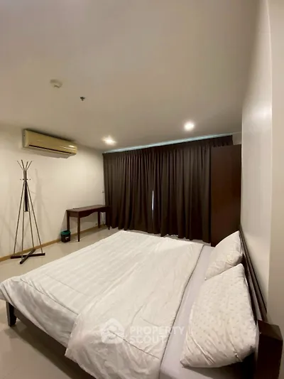 Spacious bedroom with modern furnishings and natural light