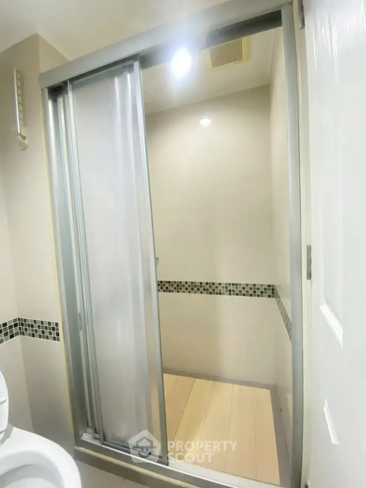 Modern bathroom with sleek shower enclosure and stylish tile accents.