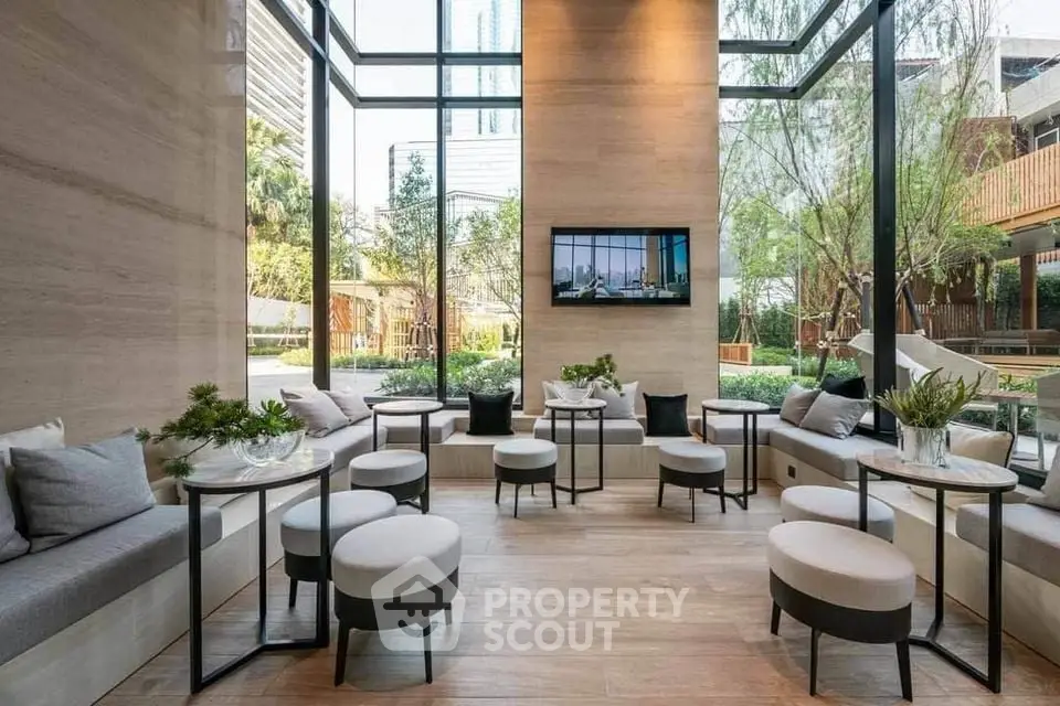 Luxurious modern lounge with floor-to-ceiling windows and elegant seating in a serene garden setting.