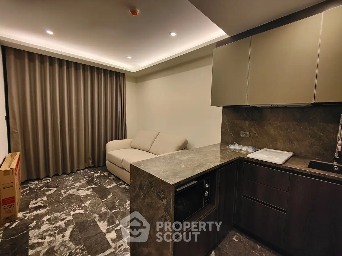 Modern living room with sleek kitchen and elegant marble flooring