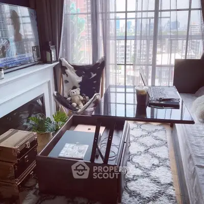 Cozy living room with city view, featuring stylish decor and modern furniture.