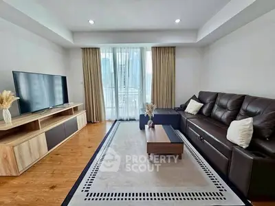 Modern living room with sleek furniture and large TV, featuring a cozy ambiance and natural light.