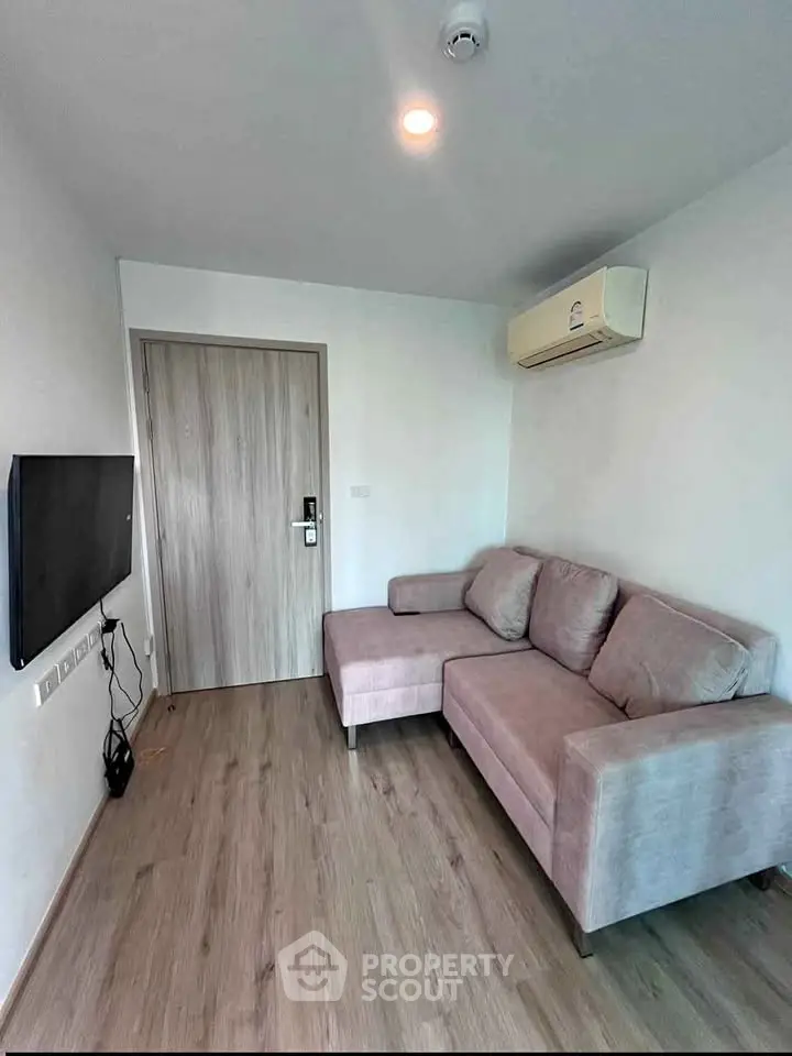 Modern living room with cozy sofa and wall-mounted TV in a stylish apartment.