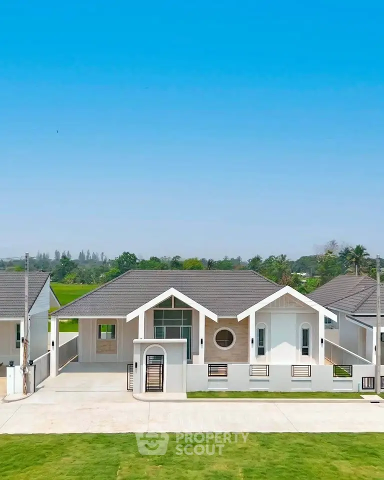 Charming modern bungalow with lush green surroundings and clear blue sky, perfect for serene living.