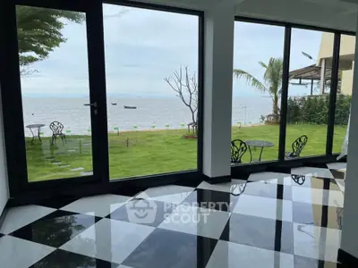 Stunning waterfront view from modern interior with checkered floor and large windows.