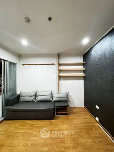 Modern living room with sleek gray sofa and wooden flooring