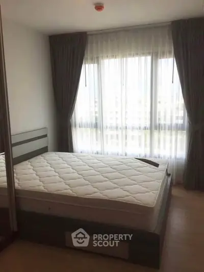 Bright bedroom with large window and modern decor in a stylish apartment.