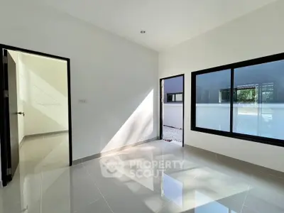 Spacious modern room with glossy tiled floors and large window, perfect for natural light.