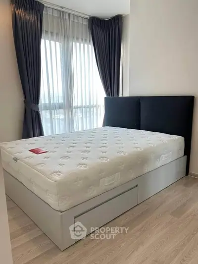 Modern bedroom with large window and stylish bed in a bright apartment.