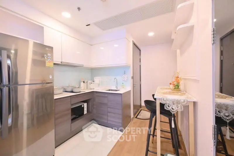 Modern kitchen with sleek appliances and breakfast bar in a stylish apartment.