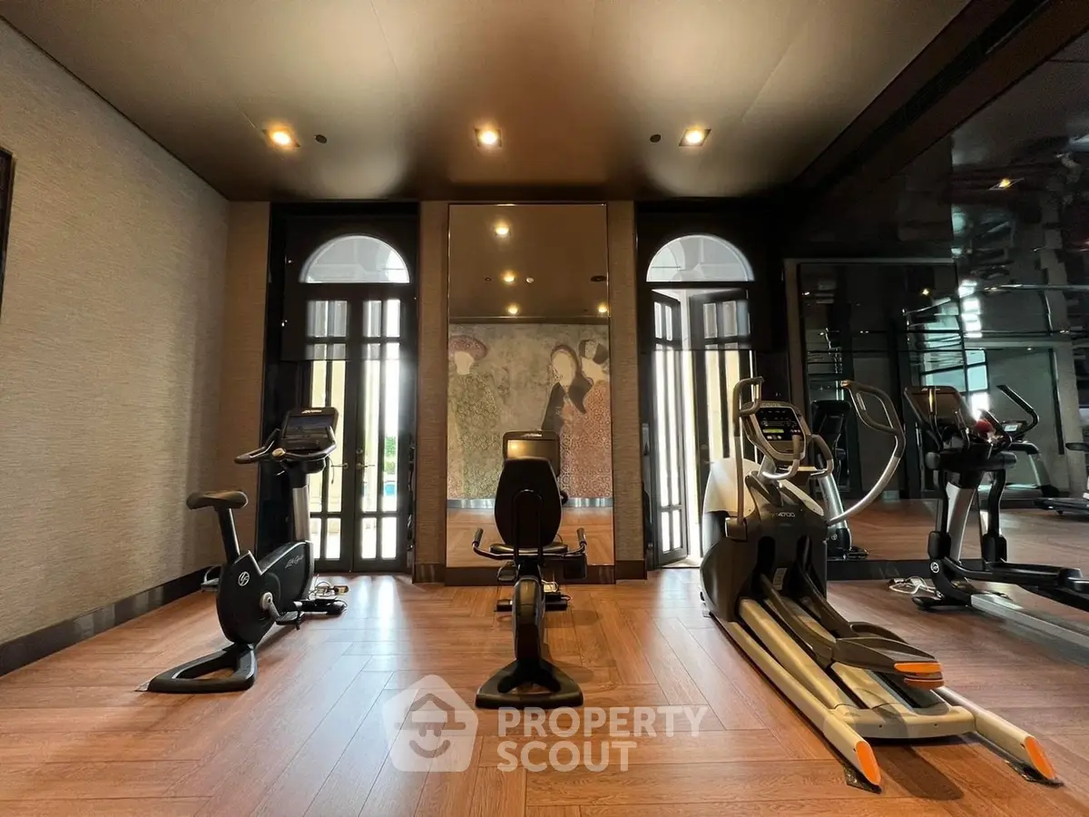 Luxurious gym with modern equipment and elegant decor in upscale residential building.
