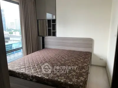 Cozy bedroom with city view, featuring a stylish bed and modern decor.