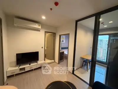 Modern apartment living room with TV, air conditioning, and balcony view.