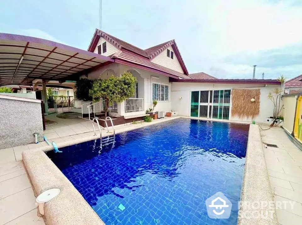 Charming house with a spacious blue-tiled swimming pool and covered patio area.