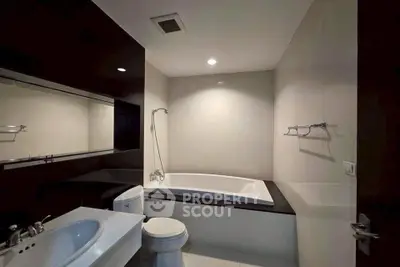 Modern bathroom with sleek design featuring a bathtub and elegant fixtures.