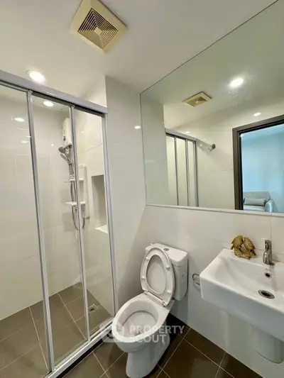 Modern bathroom with glass shower and sleek fixtures in a contemporary apartment.