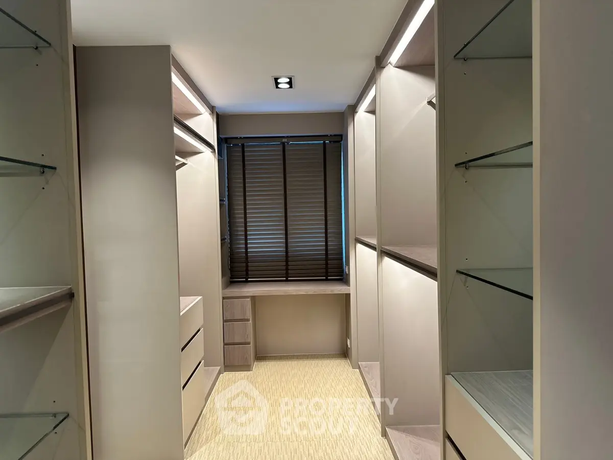 Luxurious walk-in closet with ample storage and elegant lighting