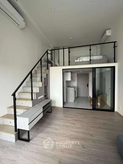 Modern loft apartment with mezzanine, sleek staircase, and open kitchen layout.
