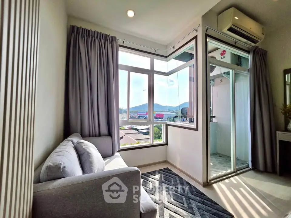 Cozy living room with large windows and scenic view, featuring modern decor and natural light.