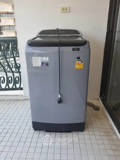 Modern washing machine on tiled balcony with elegant railing