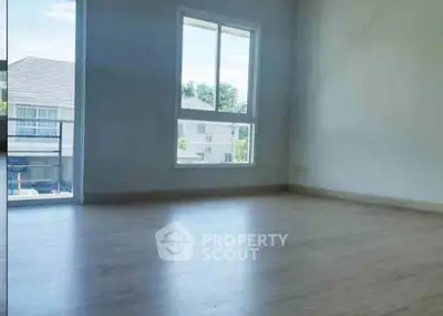 Spacious empty room with large window and balcony view