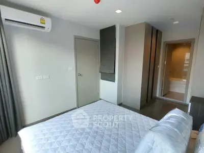 Modern bedroom with ensuite bathroom and air conditioning in a stylish apartment.