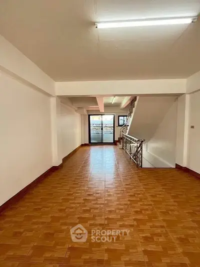 Spacious open-plan living area with tiled flooring and staircase, ideal for customization.