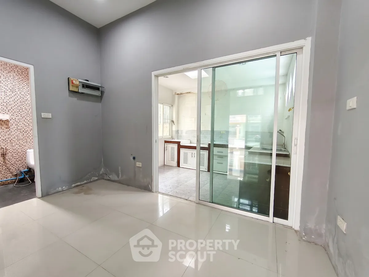 Spacious modern interior with sliding glass doors leading to a bright kitchen area.