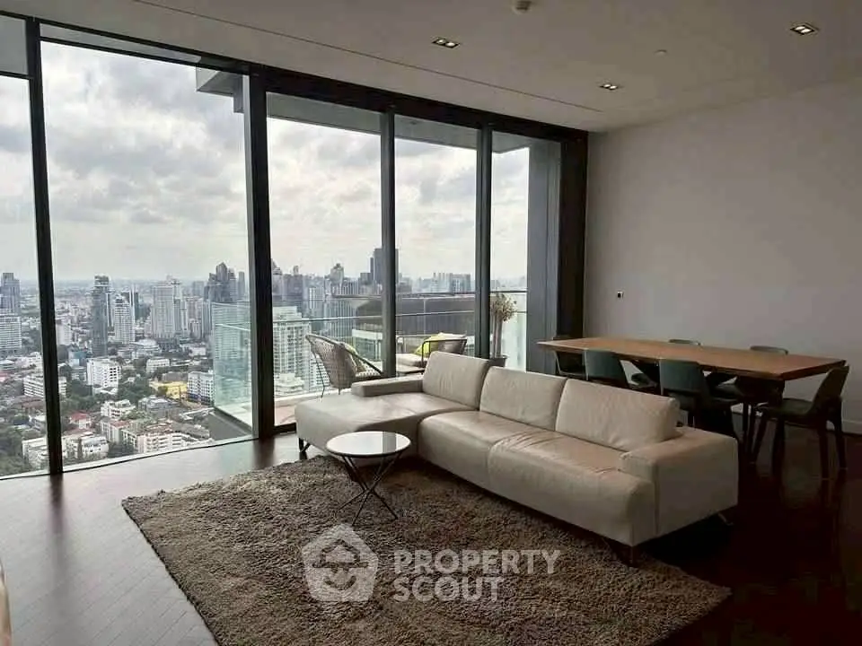 Luxurious high-rise living room with stunning city skyline view, modern furniture, and floor-to-ceiling windows.