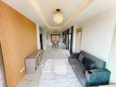 Luxurious modern living room with elegant chandelier and plush grey sofa