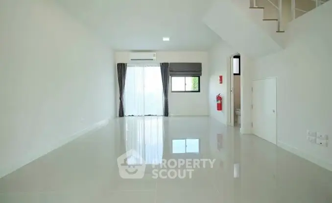 Spacious minimalist living room with glossy floor and natural light