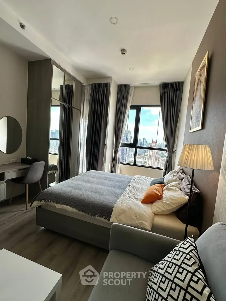 Luxurious bedroom with city view, modern decor, and ample natural light in high-rise apartment.