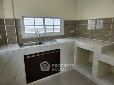 Modern kitchen with sleek marble countertops and stylish tile backsplash.