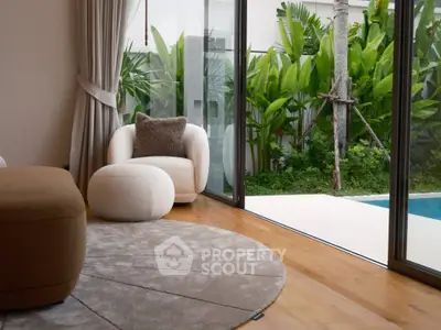Luxurious living room with pool view and modern decor, featuring plush seating and lush greenery.