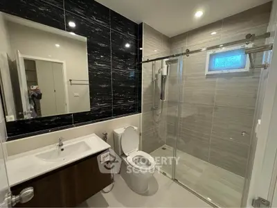 Modern bathroom with sleek design, glass shower, and stylish fixtures in a contemporary home.