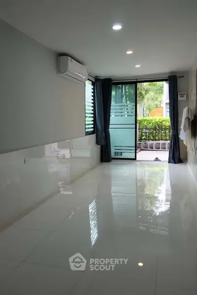Spacious modern living room with large windows and garden view, perfect for natural light lovers.