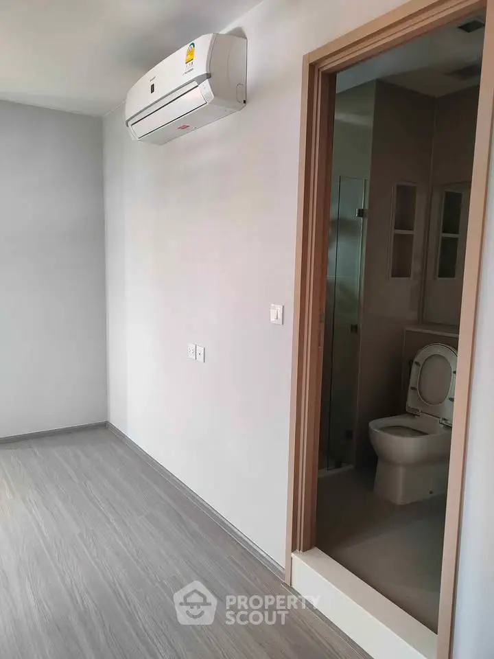 Modern minimalist room with air conditioning and ensuite bathroom, perfect for urban living.