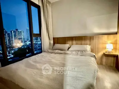 Cozy bedroom with city view, featuring a comfortable bed and ambient lighting, perfect for relaxation.